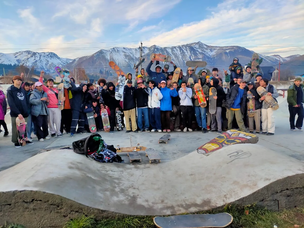 Ronda de skaters con la cordillera nevada de fondo